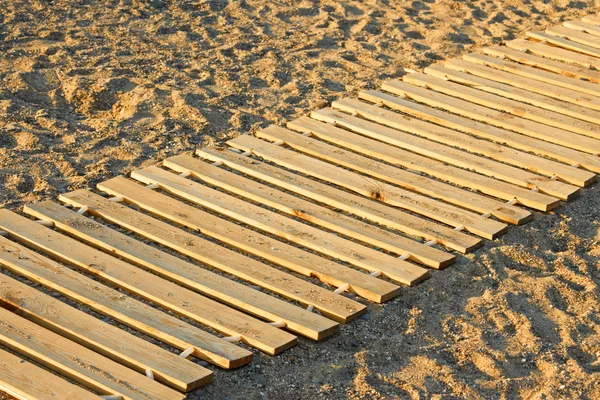 Alfombra de madera en una playa de arena —  Fotos de Stock