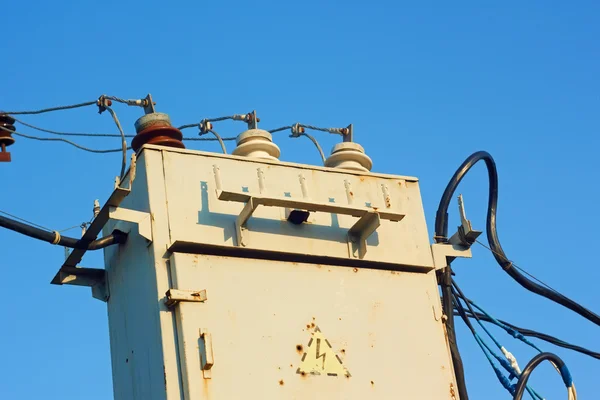 Starý transformátor proti modré obloze — Stock fotografie
