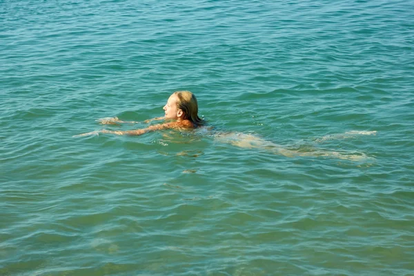 Tienermeisje zwemmen in het zeewater — Stockfoto