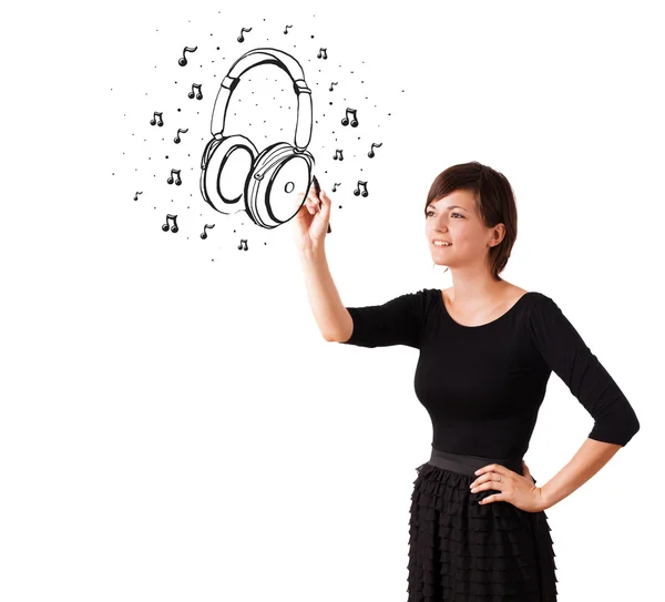 Young girl drawing headphone and musical notes — Stock Photo, Image