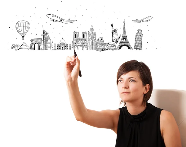 Young woman drawing famous cities and landmarks on whiteboard — Stock Photo, Image