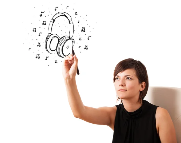 Chica joven dibujando auriculares y notas musicales —  Fotos de Stock