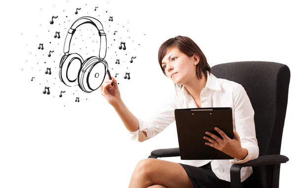 Young girl drawing headphone and musical notes — Stock Photo, Image