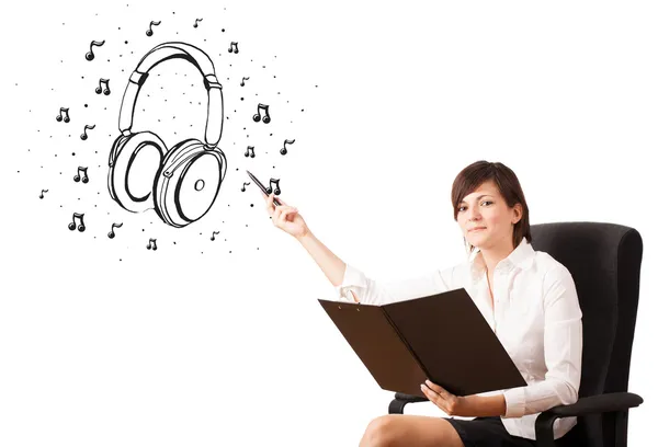 Young girl presenting headphone and musical notes — Stock Photo, Image