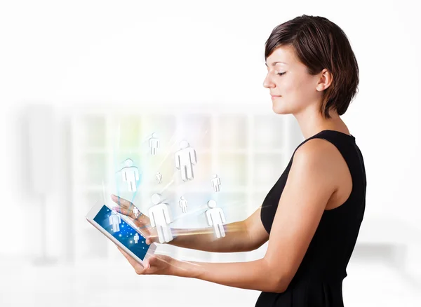 Mujer joven mirando la tableta moderna con iconos sociales —  Fotos de Stock