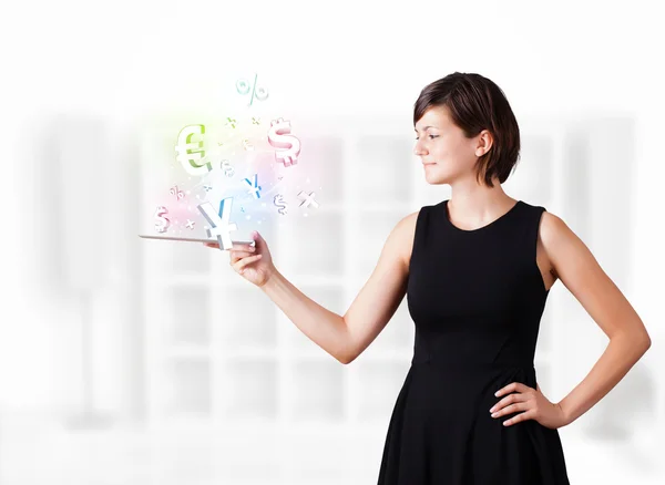 Young woman looking at modern tablet with currency icons — Stock Photo, Image
