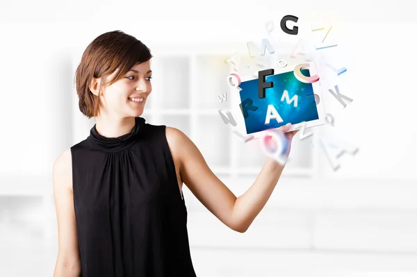 Young woman looking at modern tablet with alphabet — Stock Photo, Image