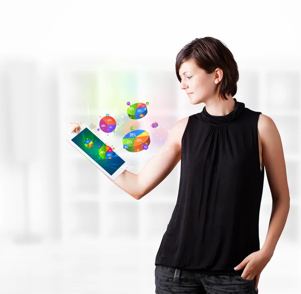 Mujer joven mirando la tableta moderna con gráficos de pastel —  Fotos de Stock