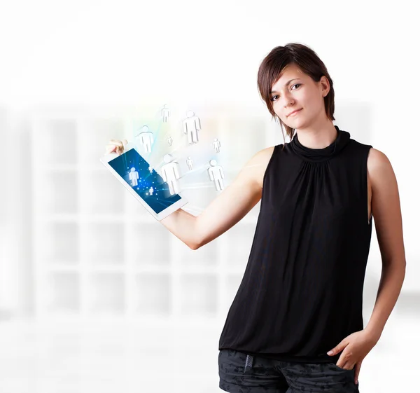 Young woman looking at modern tablet with social icons — Stock Photo, Image