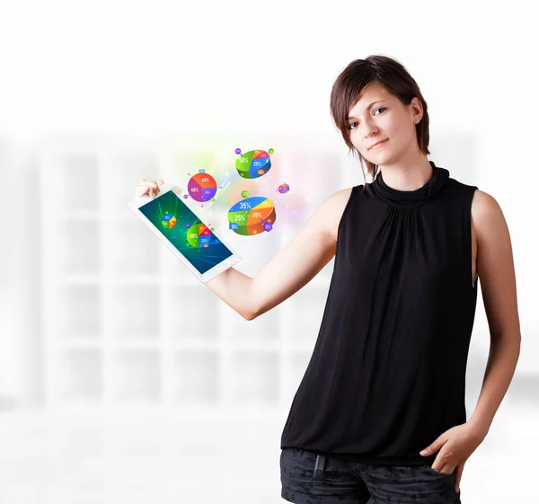 Mujer joven mirando la tableta moderna con gráficos de pastel —  Fotos de Stock