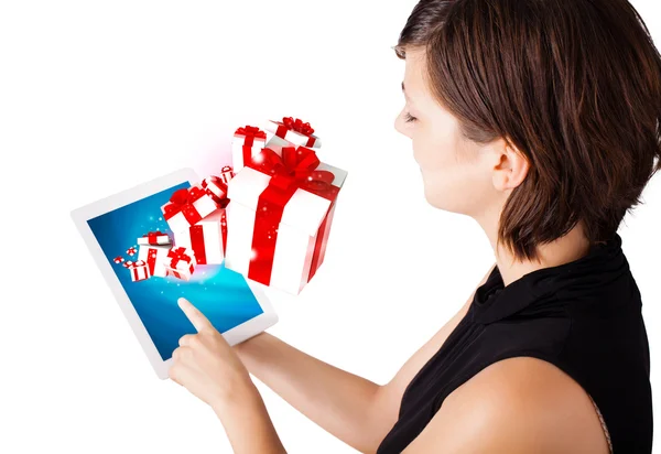 Молодая женщина смотрит на современный планшет с подарками — стоковое фото