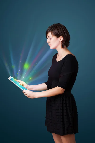 Jeune femme regardant tablette moderne avec des lumières abstraites — Photo