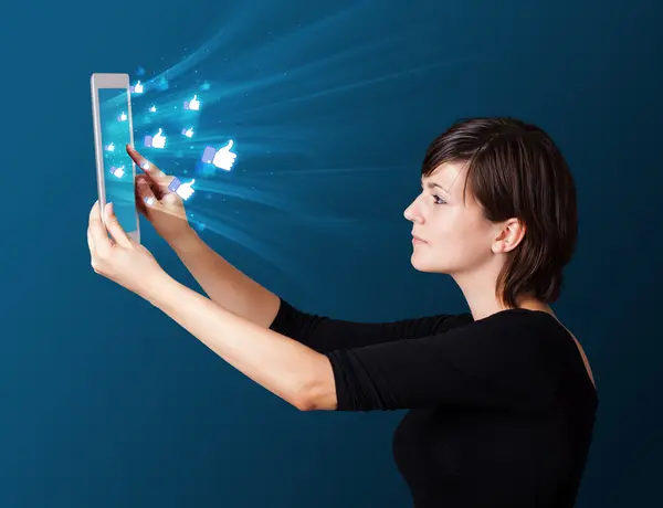 Mujer joven mirando la tableta moderna con luces abstractas y así —  Fotos de Stock