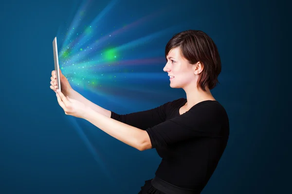 Jeune femme regardant tablette moderne avec des lumières abstraites — Photo