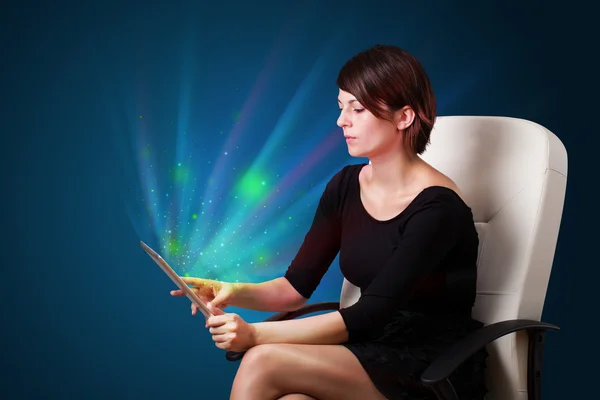 Young woman looking at modern tablet with abstract lights — Stock Photo, Image