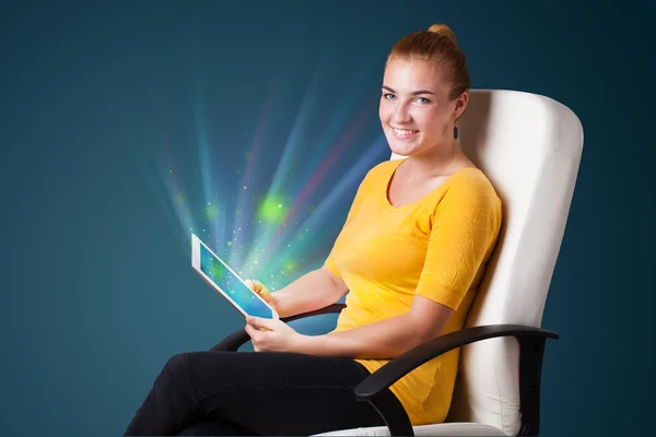 Young woman looking at modern tablet with abstract lights — Stock Photo, Image