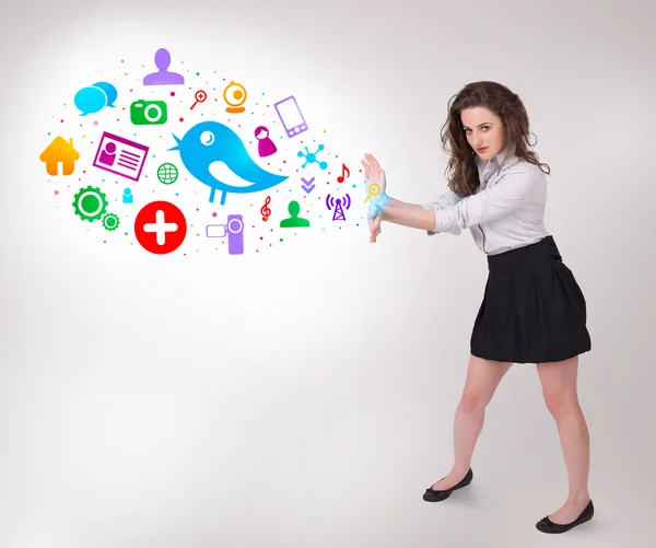 Young business woman presenting colourful social icons — Stock Photo, Image
