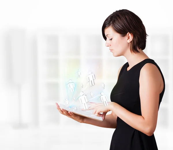 Young woman looking at modern tablet with social icons — Stock Photo, Image