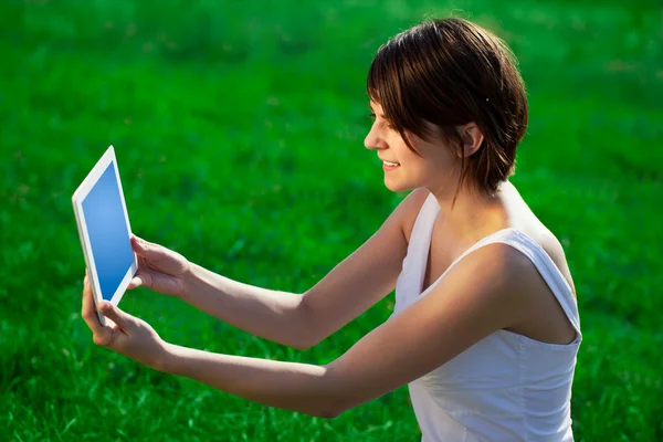 Jonge vrouw te kijken naar moderne Tablet PC — Stockfoto