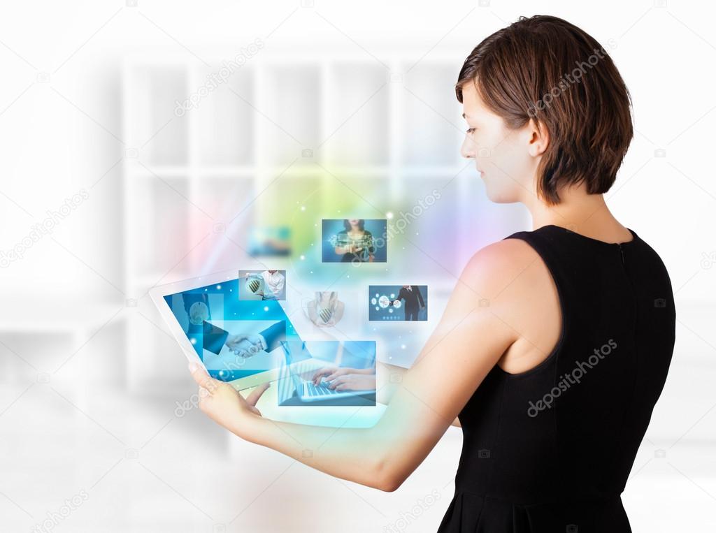 Young woman browsing pictures on modern tablet