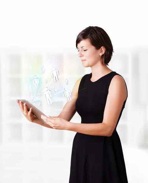 Jovem mulher olhando para tablet moderno com ícones sociais — Fotografia de Stock