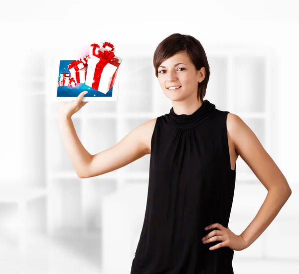 Mujer joven mirando la tableta moderna con cajas de regalo —  Fotos de Stock