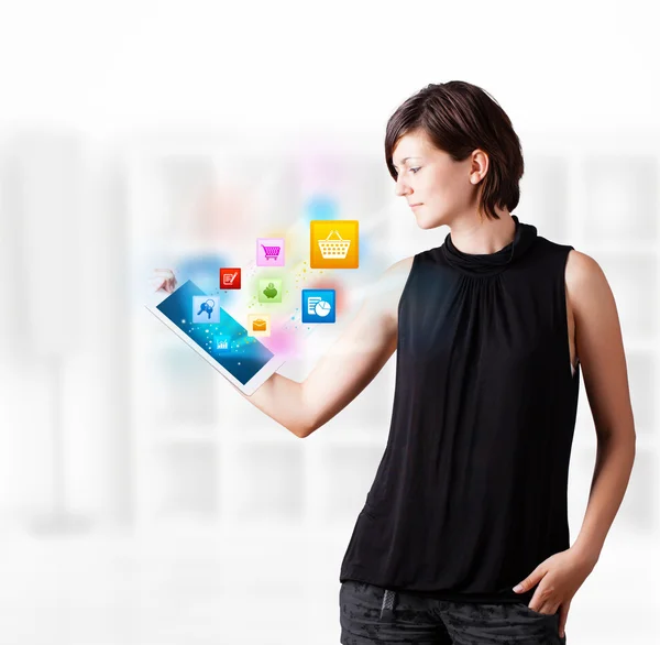 Ung kvinna tittar på moderna tablet med färgglada ikoner — Stockfoto
