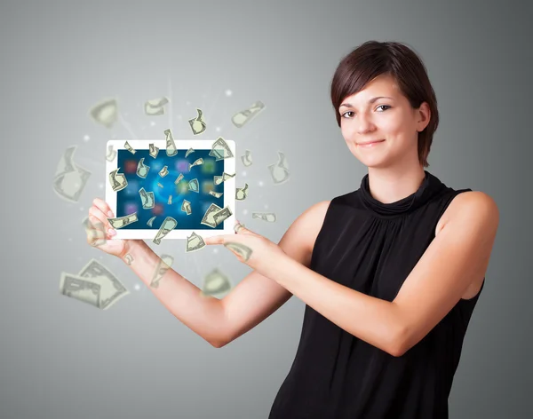 Young woman holding tablet with money — Stock Photo, Image