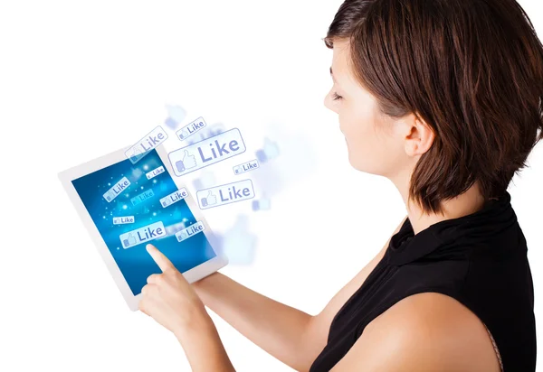 Young woman looking at modern tablet with social icons — Stock Photo, Image