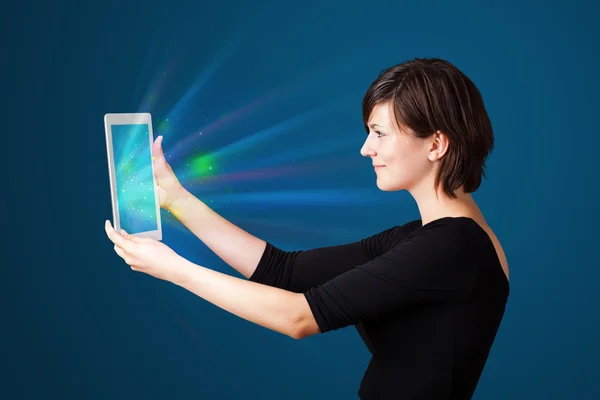 Junge Frau blickt auf modernes Tablet mit abstrakten Lichtern — Stockfoto