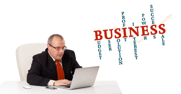 Bisinessman sitting at desk and looking laptop with business wor — Stock Photo, Image