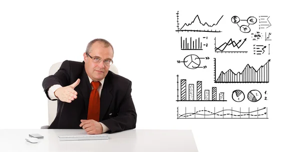 Бизнесмен сидит за столом с диаграммами и графиками — стоковое фото