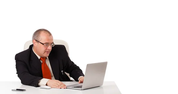 Geschäftsmann sitzt am Schreibtisch und sucht Laptop mit Kopierplatz — Stockfoto