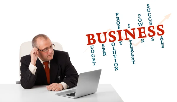 Bisinessman sitting at desk and looking laptop with business wor — Stock Photo, Image