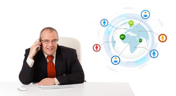 Businessman sitting at desk and making a phone call with globe a Royalty Free Stock Images