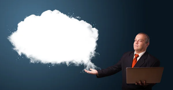 Geschäftsmann hält Laptop in der Hand und präsentiert abstrakte Cloud-Kopie — Stockfoto