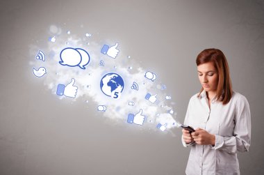 Sosyal medya simgeleriyle telefon tutan güzel bir genç kız.