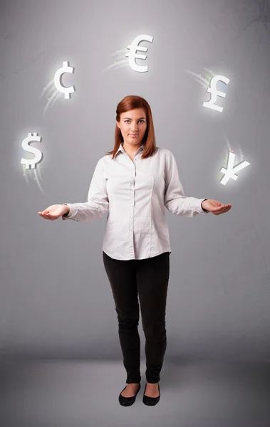 Young lady standing and juggling with currency icons — Stock Photo, Image