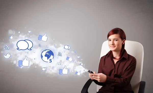 Pretty young girl holding a phone with social media icons — Stock Photo, Image