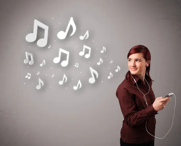 Jolie jeune femme chantant et écoutant de la musique avec n musical — Photo