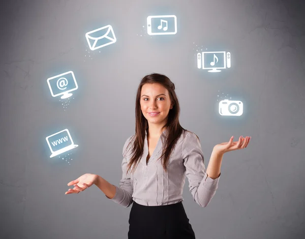 Pretty girl juggling with elecrtonic devices icons — Stock Photo, Image