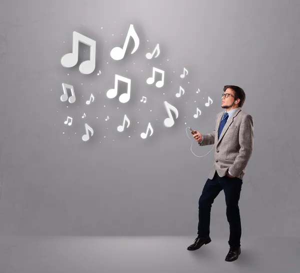 Attractive young man singing and listening to music with musical — Stock Photo, Image