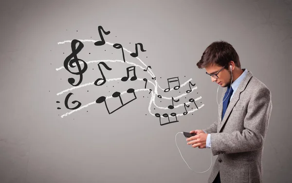 Handsome boy singing and listening to music with musical notes — Stock Photo, Image