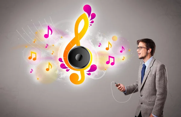 Young man singing and listening to music with musical notes — Stock Photo, Image