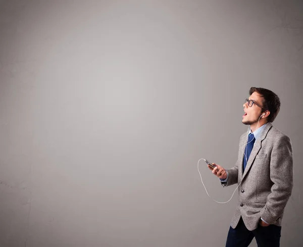 Hombre guapo cantando y escuchando música con espacio para copiar — Foto de Stock