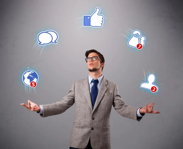 Knappe jongen jongleren met social media iconen — Stockfoto