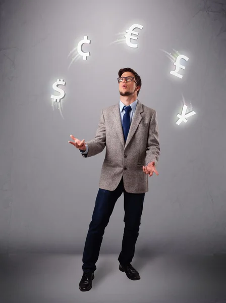 Joven de pie y haciendo malabares con iconos de moneda — Foto de Stock