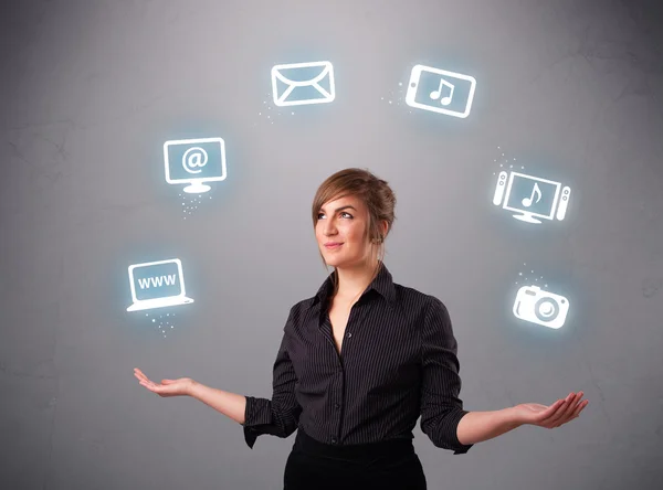 Pretty girl juggling with elecrtonic devices icons — Stock Photo, Image