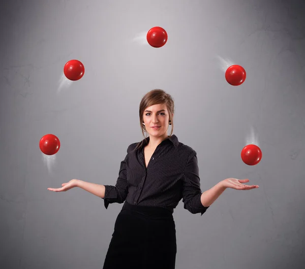 Giovane ragazza in piedi e giocoleria con le palle rosse — Foto Stock