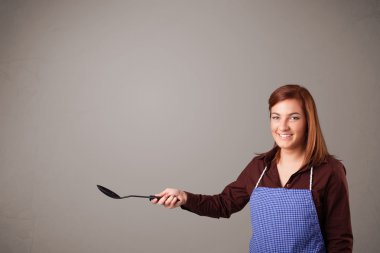 Güzel bir kadın kaşık tutuyor.